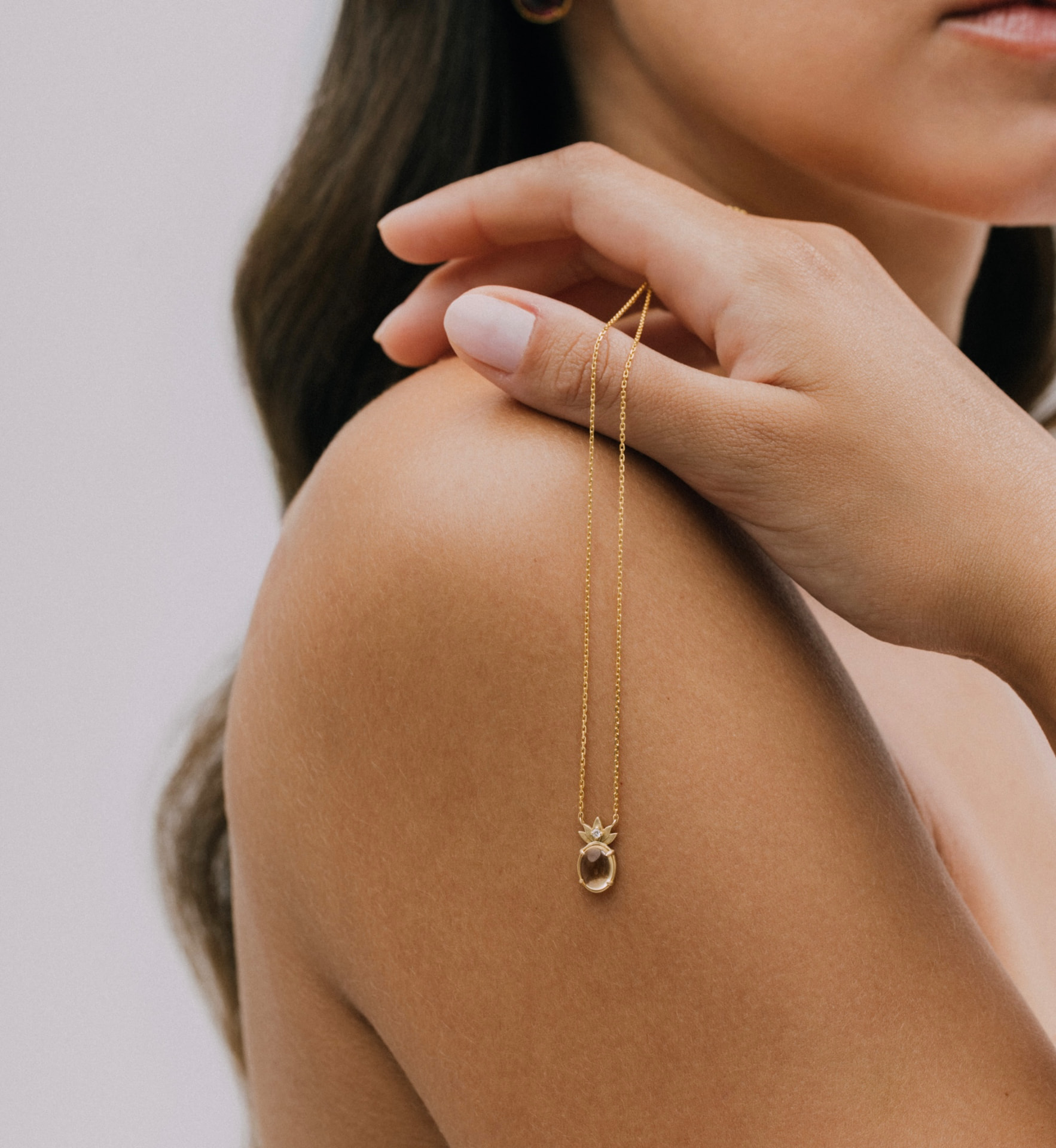 The THALYRA pendant worn at the collarbone